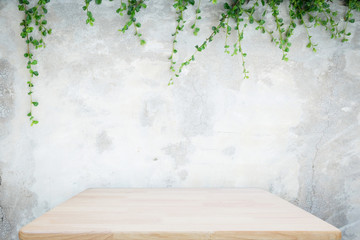 Wooden table with concrete wall and ornamental plants or ivy or garden tree for background. - Powered by Adobe