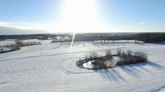 aerial view  fly over beautiful snowy landscape with sun and blue sky in germany - dronen flight