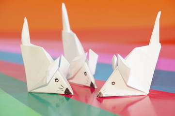 Paper origami mouse isolated on the colorful background