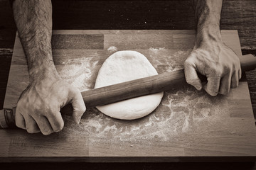 Making handmade pasta with wooden rolling pin