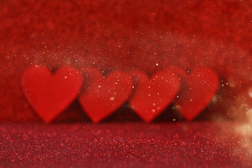 Wooden red hearts on red shiny background