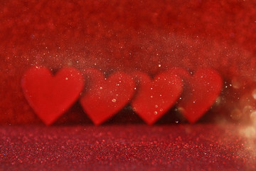 Wooden red hearts on red shiny background