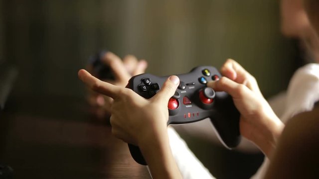 Man playing video game with a joystick. close-up of children's hands