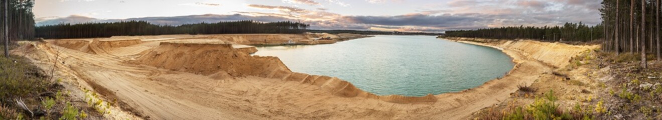 Sand quarry with blue lake under the magnificient sky.