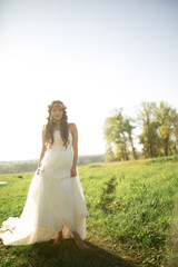 Fototapeta na wymiar Beautiful bride in wedding dress and with a lovely mood in nature
