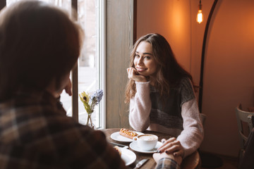 Loving young couple in cafe looking at each other.