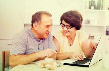 Fototapeta na wymiar mature couple looking on laptop at home.