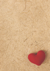 Obraz na płótnie Canvas Blurred vintage valentine concept background, red heart on natural texture paper background
