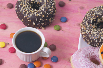 Cup of coffee and donuts on wood