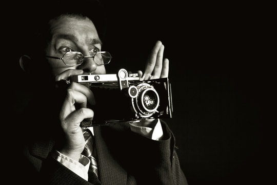 Young and attractive photographer in vintage suit and with retro