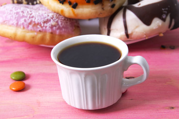 Cup of coffee and donuts on wood