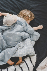 Маленький малчьик спит в кроватке с игрушкой