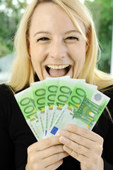 Frau mit vielen Euro Geldscheinen aus Erbe Gewinn oder Preisausschreiben freut sich 