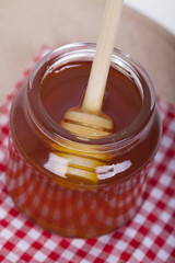 Honey in jar on a wooden background