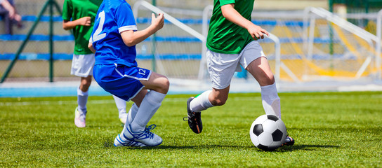 Children Soccer Players Running with the Ball. Kids in Blue and Green Soccer Jerseys Playing...
