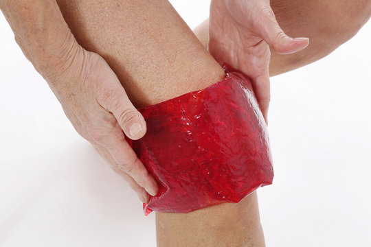 femme senior posant compresse gel th&eacute;rapeuthique sur son genou