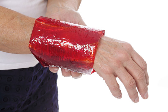 femme senior posant compresse gel th&eacute;rapeuthique sur son poignet