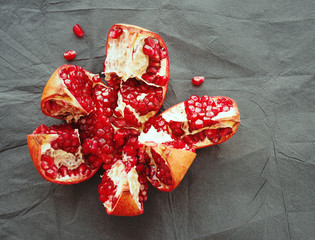 Red juicy pomegranate fruit , close up on a dark surface