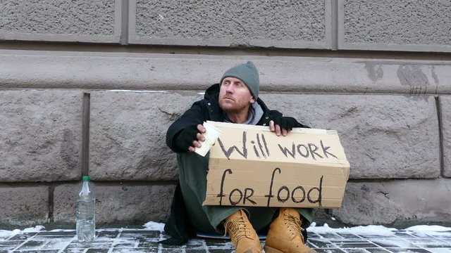 
4K.Some money for Homeless  despair man  in  city street . Unemployment symbol
