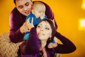 The mother,father and son sitting on the chair