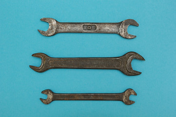 Three old wrenches on a blue background