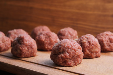 meat balls from raw beef force-meat on a chopping board