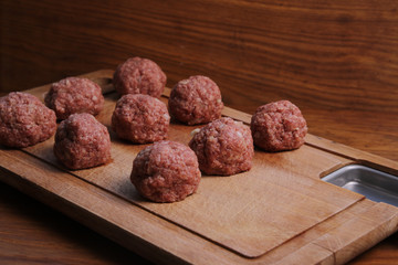 meat balls from raw beef force-meat on a chopping board