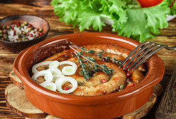 Baked homemade chicken sausage with spices and thyme. Gourmet dinner in the rustic style. Selective focus
