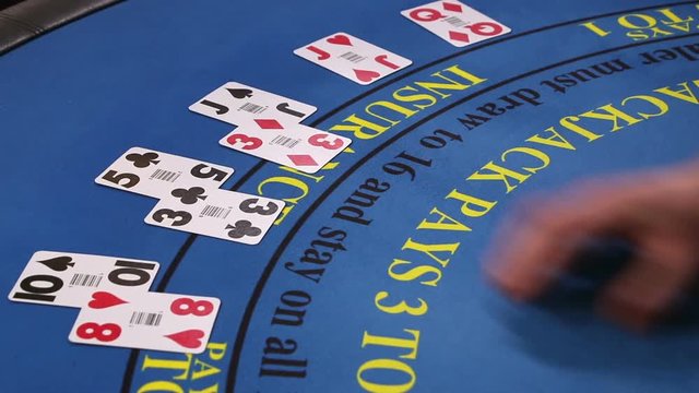 Croupier placing black jack and poker cards on the casino table, zoom shot of hands