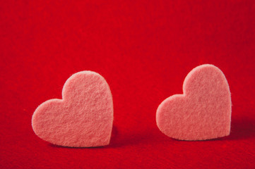 pink felt hearts on red background, valentine's day