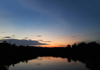 Fototapeta na wymiar Twilight sky with lake and silhouette trees