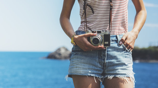 Tourist traveler photographer making pictures seascape on vintage photo camera on background yacht and boat piar, hipster girl enjoying nature holiday, mockup ocean waves view, blurred backdrop