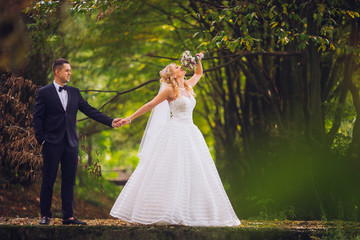 Bride and groom in a park kissing.couple newlyweds bride and groom at a wedding in nature green forest are kissing photo portrait.Wedding Couple