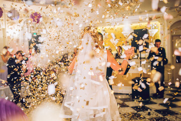 beautiful caucasian couple just married and dancing their first dance confetti around