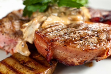 Appetizing grilled steak closeup side view. Juicy barbecue pork steak with potato and sauce. Meat meal background. Dining, junk food, restaurant menu concept