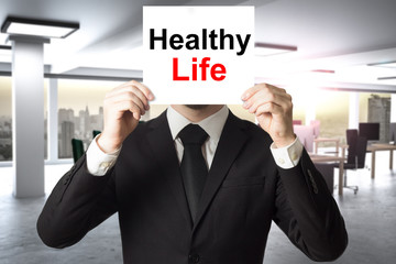 businessman hiding face behind sign healthy life