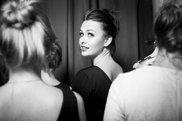 Beautiful plus-size model preparing for a runway show in dress and with make up. Backstage