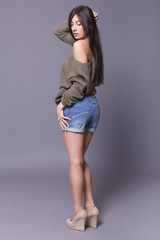 Portrait of a beautiful brunette woman model posing in jeans and