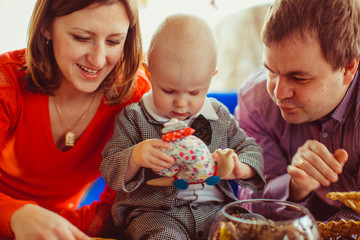 The mother,father and son sitting near table with nuts