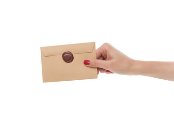 Female hand holds an envelope.