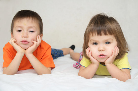 little boy and girl, brother and sister quarreling on bed, family relationships concept