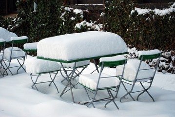 Schneebedeckter Tisch und Stühle
