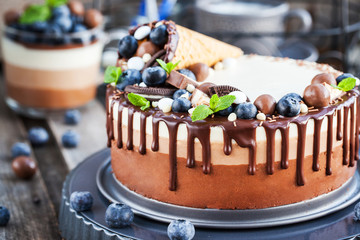 Three chocolate mousse cake decorated with waffle cone, fresh bl