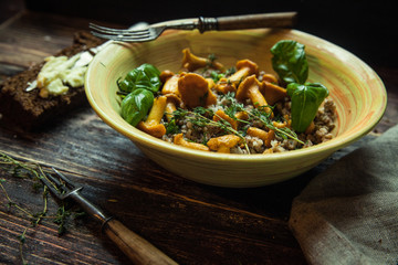 Buckwheat porridge cooked with butter in an earthenware bowl on wooden gray background. Top view, closeup.