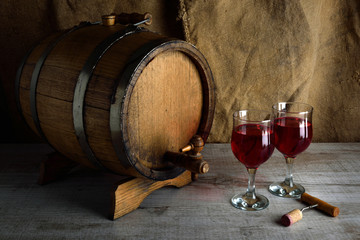 cask of wine on a wooden background with a glass of wine