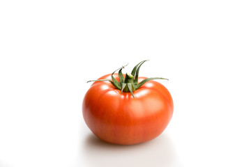 One realistic looking  tomatoe lying isolated in a white backgro
