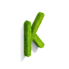 Grass letter K in uppercase format from isometric angle with shadow on ground.