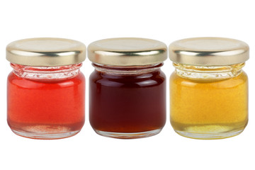 3 cans of multi-colored jams and honey isolated on white background.
