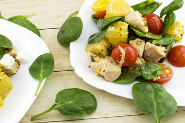 Garnished with cut feta salad from spinach, chicken, cherry tomatoes and orange