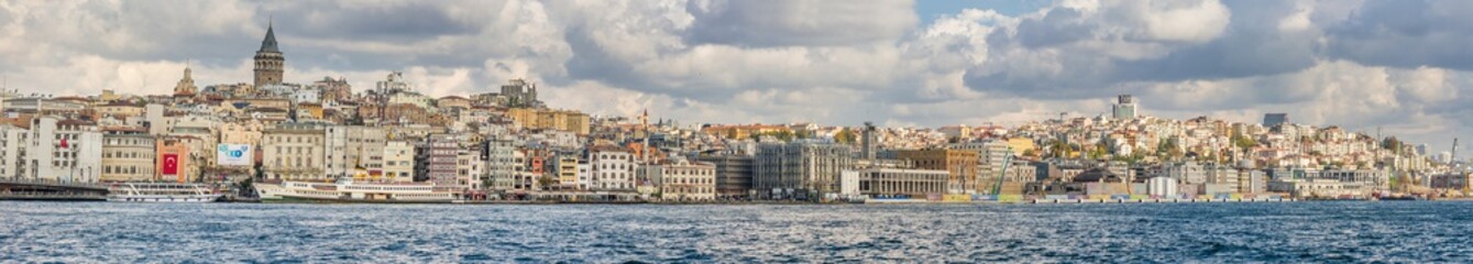 Fototapeta na wymiar Panorama of Cityscape of Golden horn with ancient and modern buildings in Istanbul Turkey from the Bosphorus strait on a sunny day with background cloudy sky